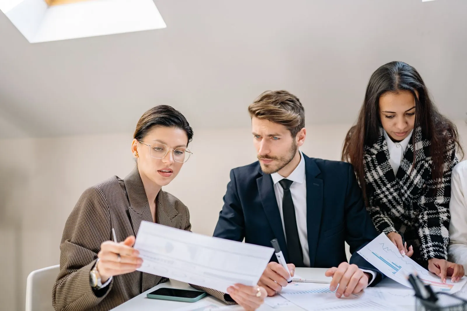 Colleagues reviewing printed statements on a table