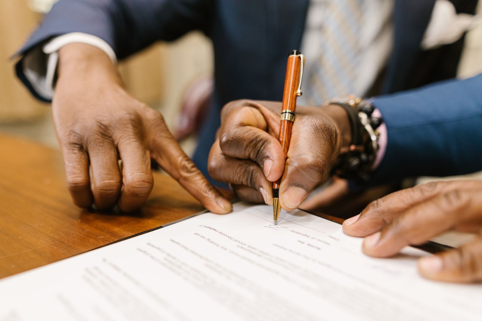 Two people signing a business contract at a desk