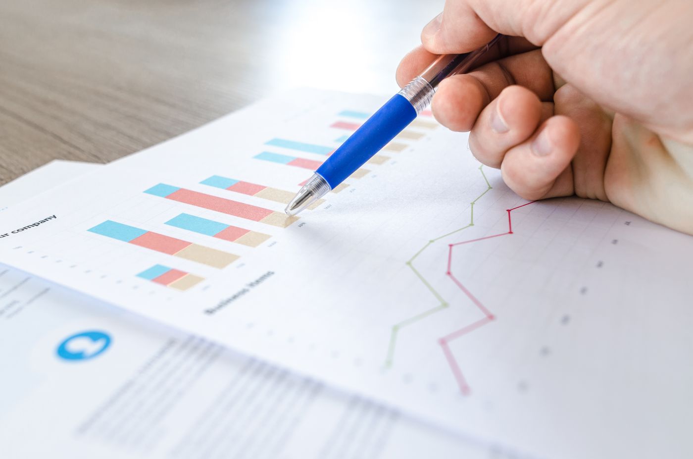 Hand checking figures on a printed worksheet